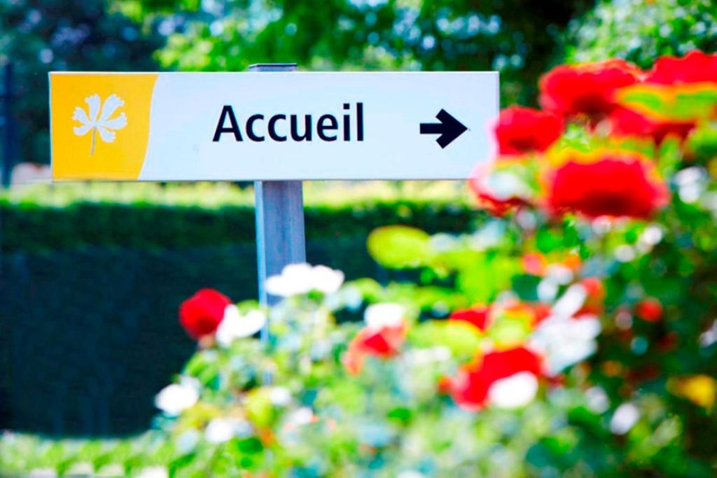 a sign for a garden with flowers in the background at Premiere Classe Cambrai Proville in Cambrai
