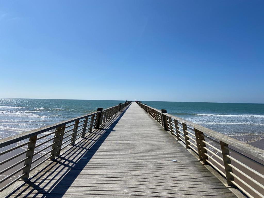 Une jetée en bois s'étend jusqu'à l'océan. dans l'établissement SUPERBE STUDIO A SAINT JEAN DE MONTS, à Saint-Jean-de-Monts