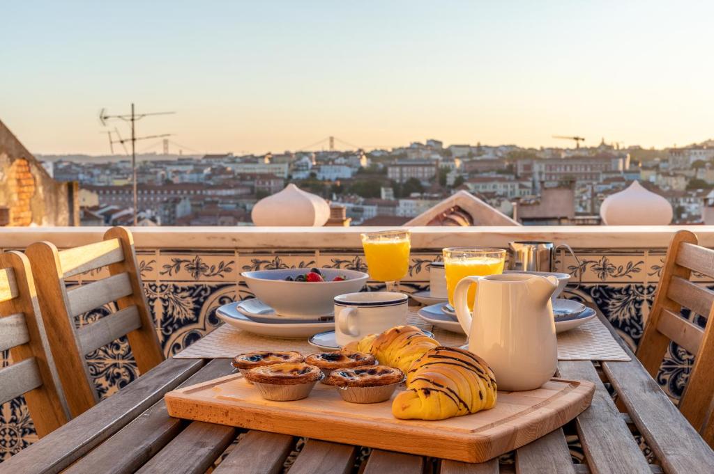 una mesa con comida y bebida en la parte superior de un balcón en Angelina Vidal Duplex with Terrace, en Lisboa
