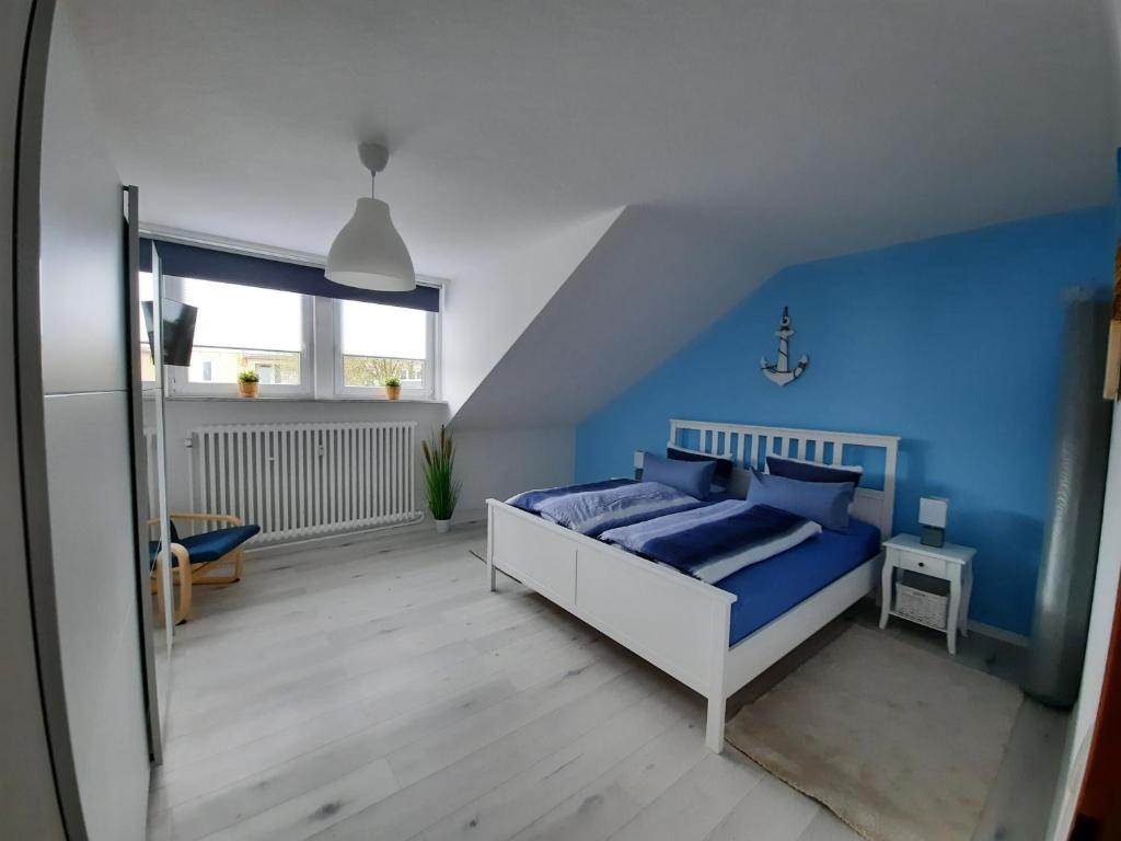 1 dormitorio con cama y pared azul en Ferienwohnung Havenstern 61, en Bremerhaven