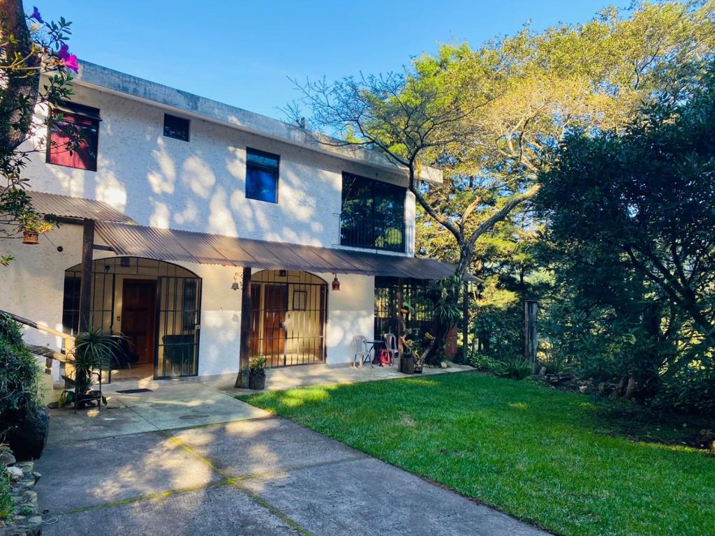 a house with a grass yard in front of it at Hotel del Bosque in Guatemala