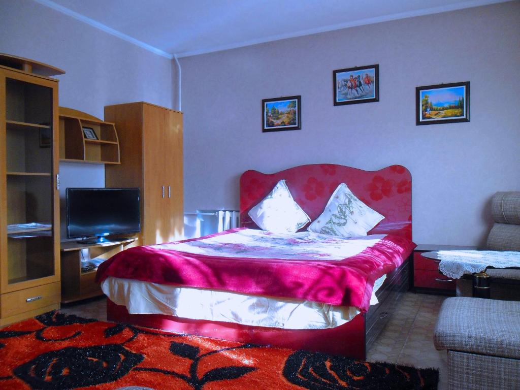 a bedroom with a bed with a red head board at Paradise Apartment in Bishkek