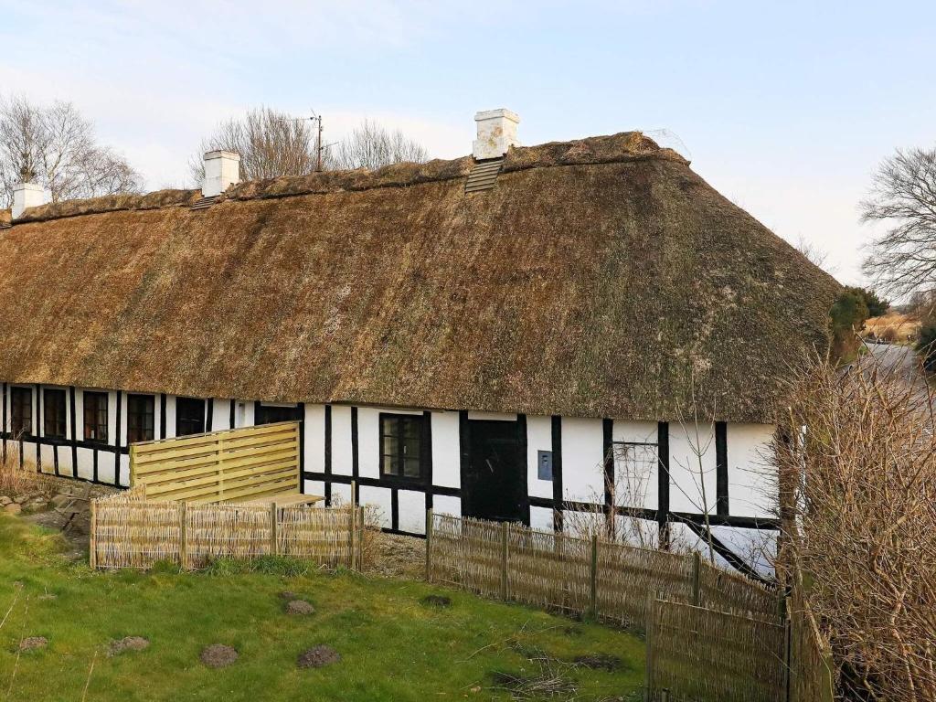 una casa antigua con techo de paja y techo de hierba en Holiday home Ebberup VI, en Ebberup