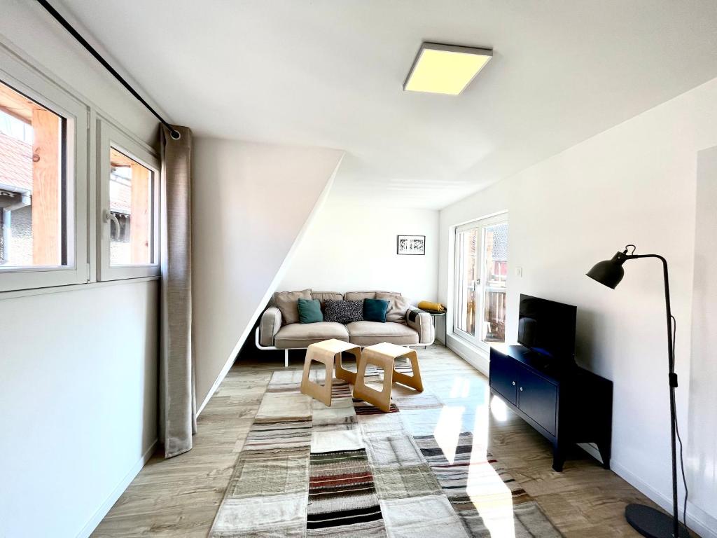 a living room with a couch and a table at Sous les toits avec garage et terrasse à Ribeauville in Ribeauvillé