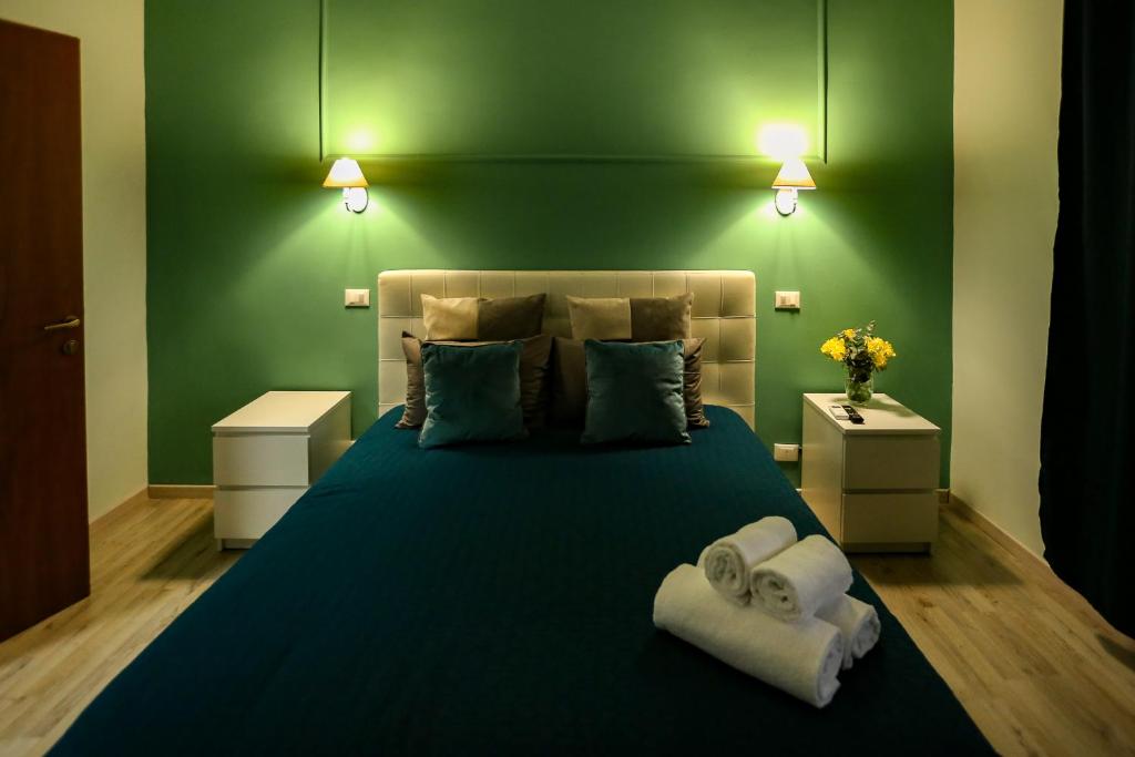 - une chambre verte avec un lit et des serviettes dans l'établissement Lydka Domus, à Rome