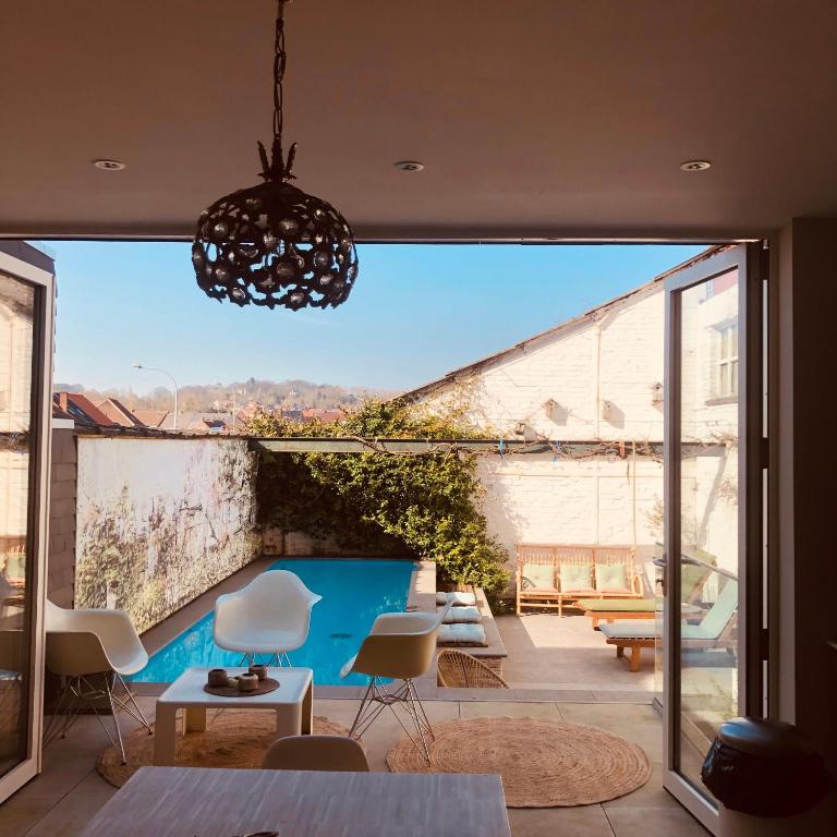 ein Haus mit Blick auf eine Terrasse mit Stühlen in der Unterkunft karaktervolle woning met zwembad te Ronse in Ronse