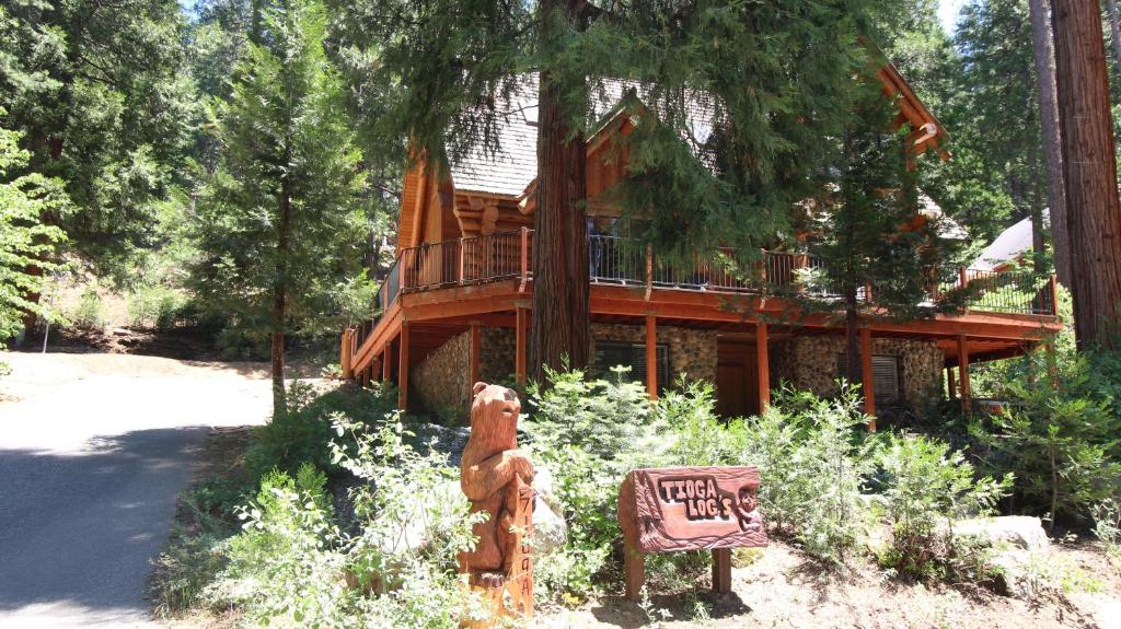 a tree house with a bear statue in front of it at Tioga Logs in Yosemite West