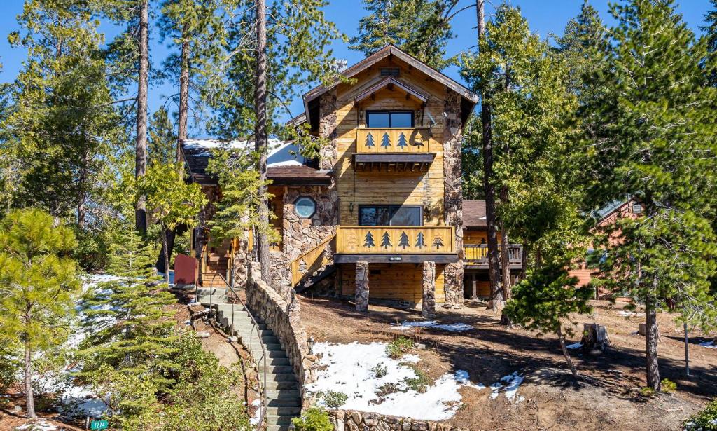 a log home in the woods with a balcony at Tree Haven in Yosemite West