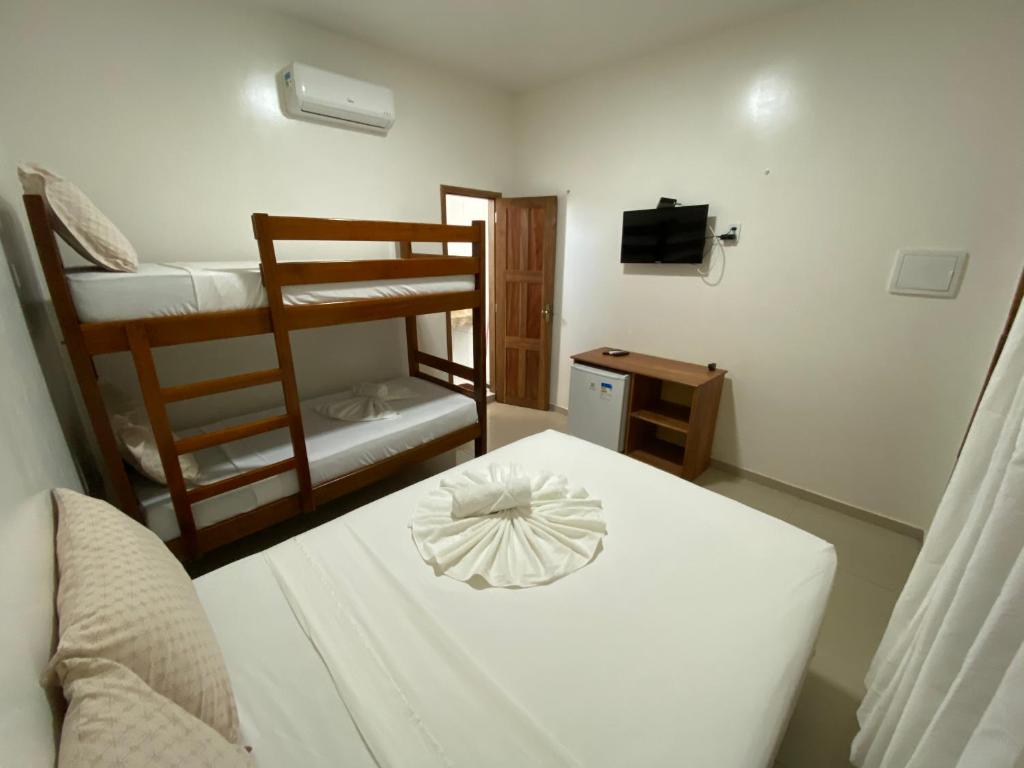 een kamer met een bed en twee stapelbedden bij Pousada Casa da Cion in Jericoacoara
