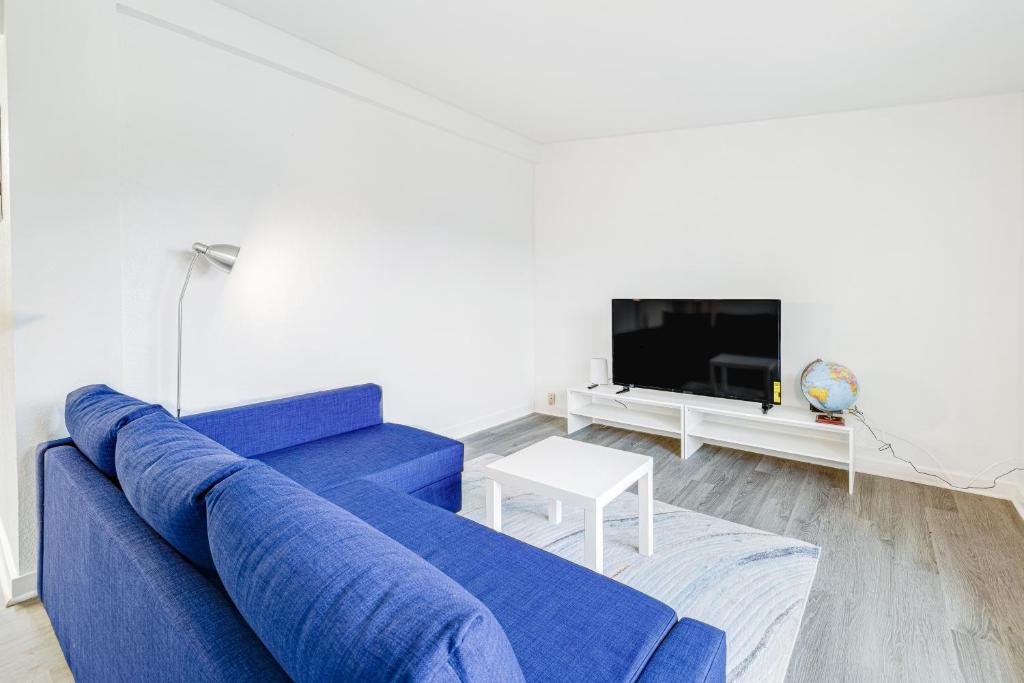 een woonkamer met een blauwe bank en een tv bij Coral Cove in Lincoln City