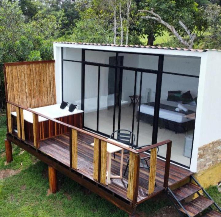 a screened in deck with a table and a chair at Glamping Barichara in Barichara