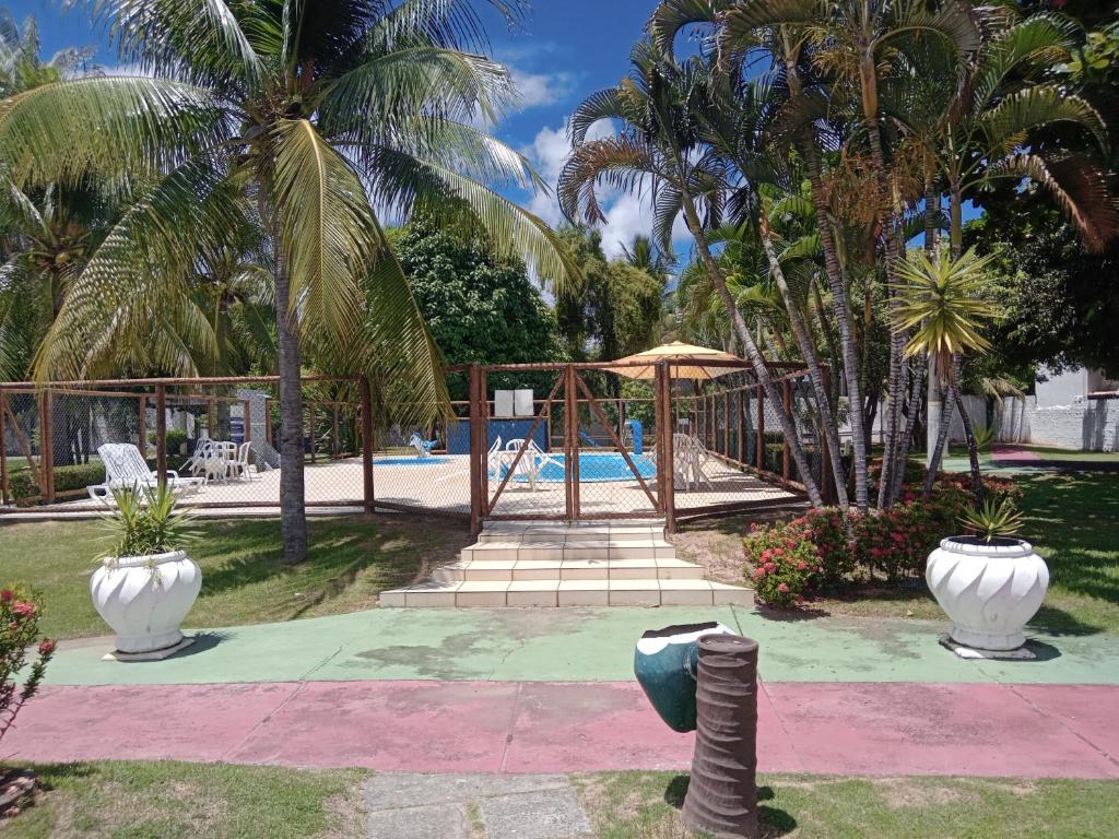 a pool with a playground with palm trees at Apts e suites em Stella Maris in Salvador