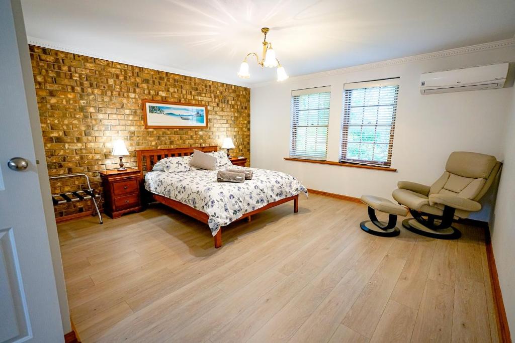 une chambre avec un lit et une chaise dedans dans l'établissement Adelaide Style Accommodation-Getaway in North Adelaide- close to city, à Adélaïde