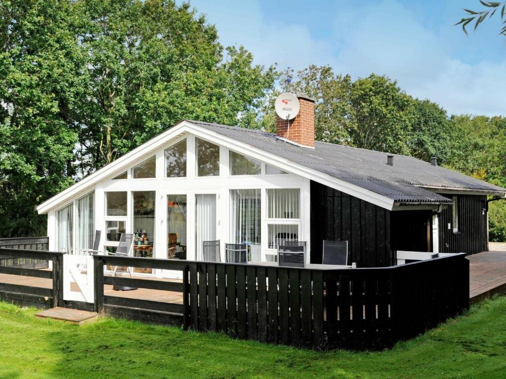 a black and white house with a deck at 8 person holiday home in Hemmet in Falen