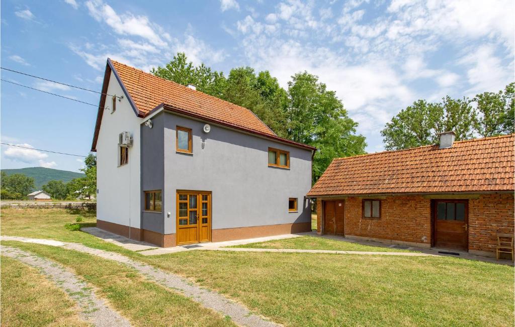 une petite maison blanche avec un toit rouge dans l'établissement Stunning Apartment In Otocac With Wifi, à Otočac