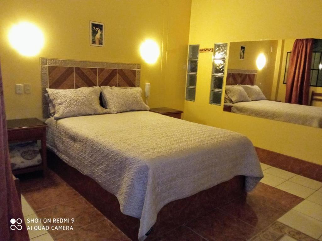 um quarto com uma cama grande e um espelho em Motel Sahara Suites em Barranca