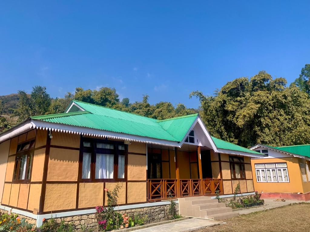 una pequeña casa con techo verde en Kazi Retreat, en Pakhyong