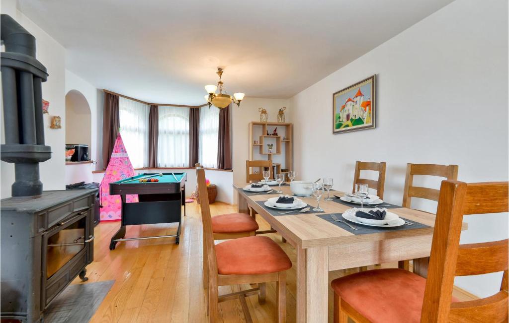 a dining room with a table and a stove at 3 Bedroom Nice Home In Rukljevina in Gornja Poljana