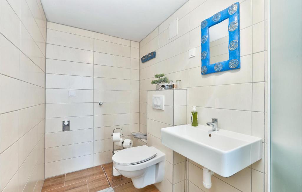a white bathroom with a toilet and a sink at 3 Bedroom Nice Home In Rukljevina in Gornja Poljana