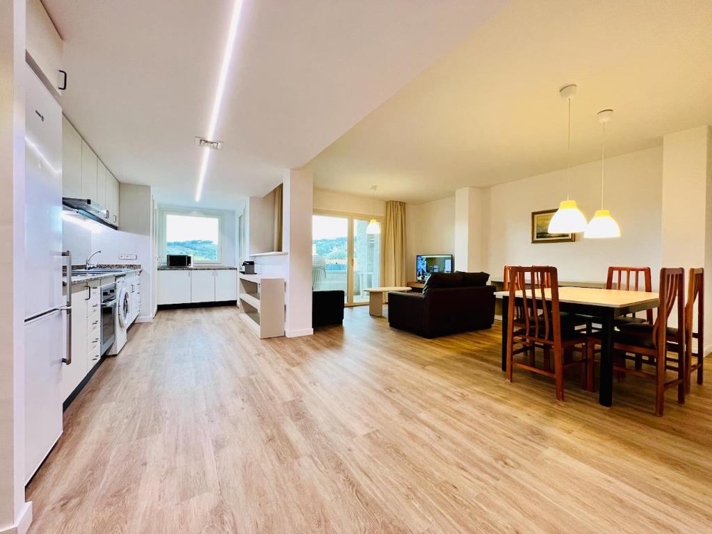 a kitchen and living room with a table and chairs at Sono Master Apartments in La Garriga