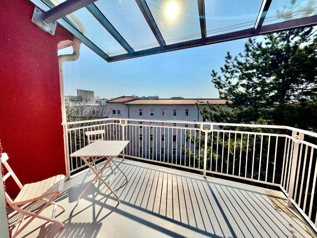 Un balcón con una mesa y una silla. en Downtown Chic Apartment Graz - Top 8 self check-in, en Graz