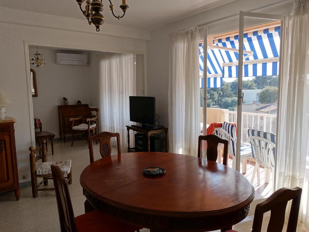 a living room with a wooden table and a television at F3 BANDOL in Bandol