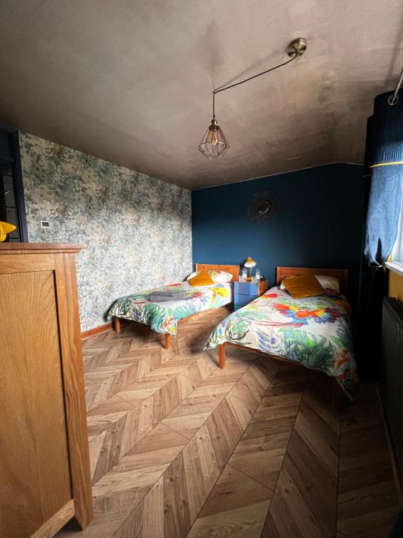 Duas camas num quarto com paredes azuis e pisos em madeira em Jackson place em Newton Aycliffe