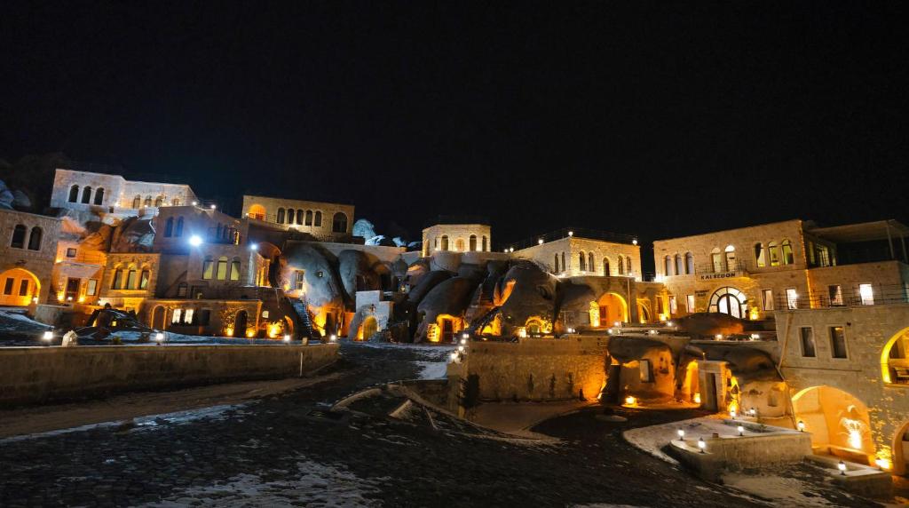 un gruppo di edifici di notte con luci di Kalsedon Cave Suites a Nevşehir