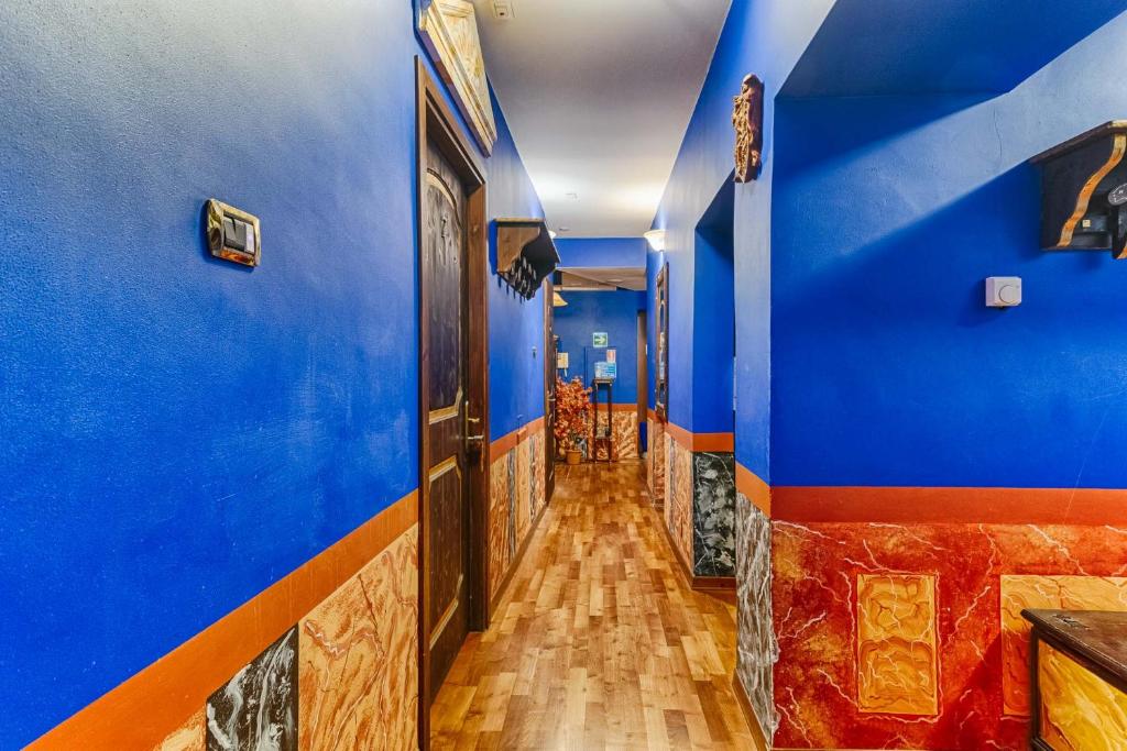 a hallway with blue walls and wooden floors at Hotel Portacavana in Trieste