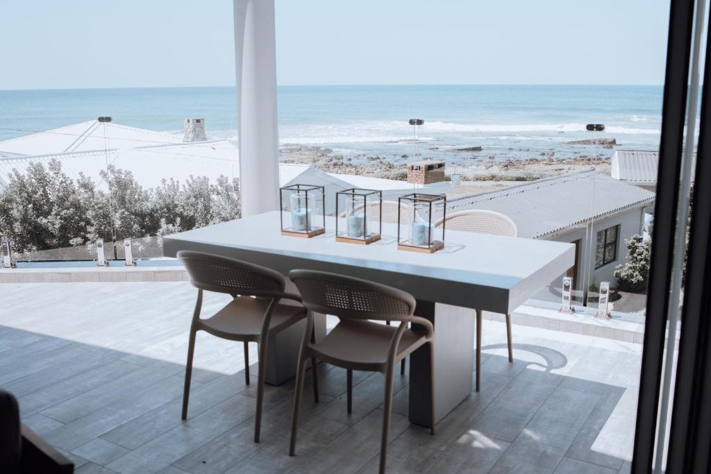 a table and chairs with a view of the beach at KnusRus in Jongensfontein