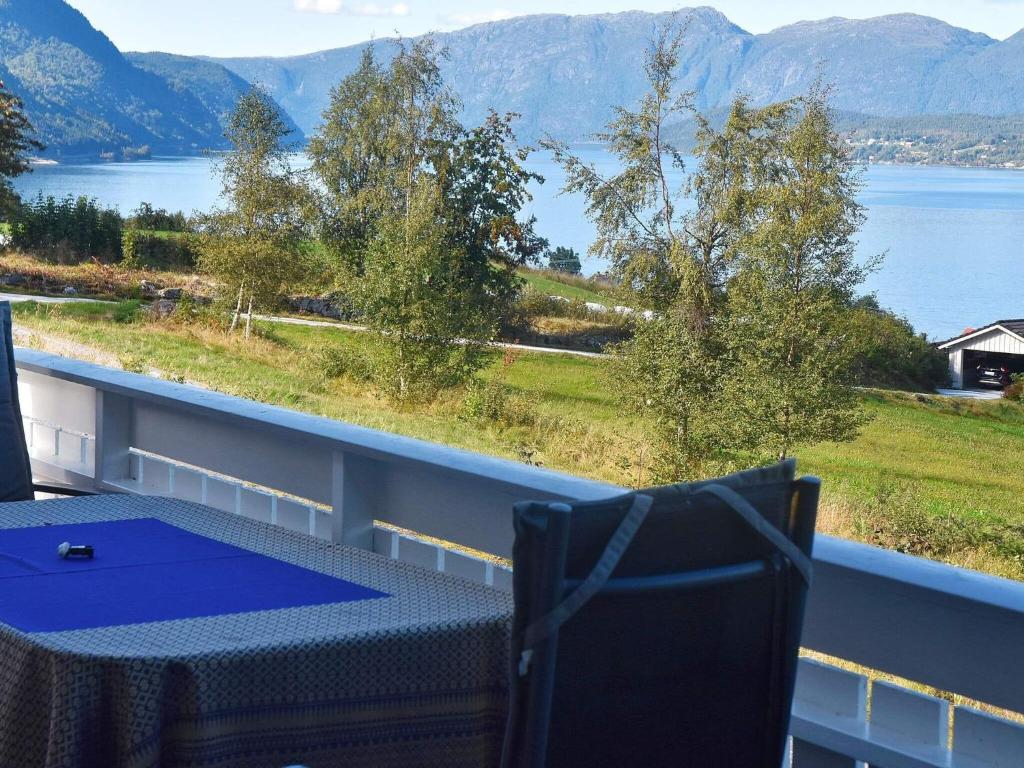 a table and chairs on a balcony with a view of a lake at Holiday home SANDANE II in Sandane