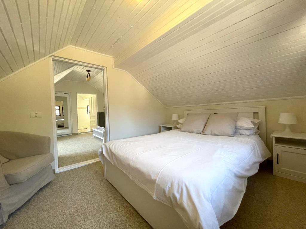 a bedroom with a large white bed and a mirror at The Nest in Sinaia