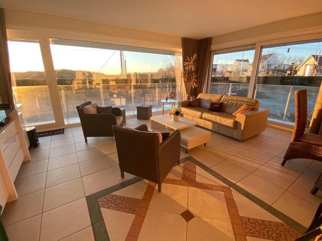 ein Wohnzimmer mit einem Sofa und einem Tisch in der Unterkunft Seadream - Modern, sunny with big terraces & open view - very close to sea, beach, shops, restaurants & beach bars in Nieuwpoort