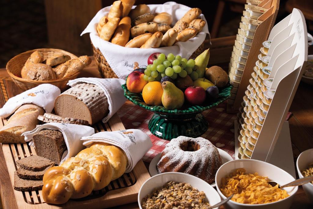une table recouverte de beaucoup de différents types de pain et de fruits dans l'établissement Hotel garni Weberhäusl, à Strobl