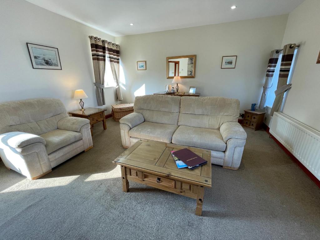 a living room with two couches and a coffee table at Chandlers BnB in Seahouses