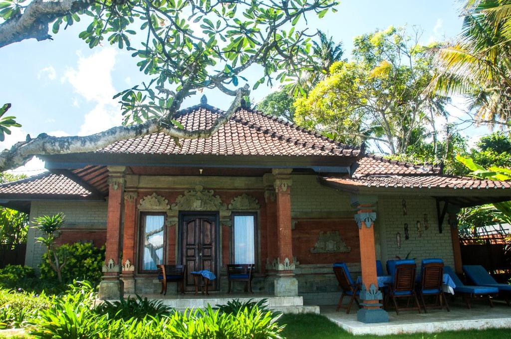 una pequeña casa con sillas delante en Villa Riens Dream, en Karangasem