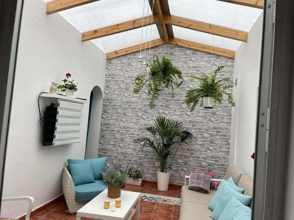 ein Wohnzimmer mit Pflanzen an einer Ziegelmauer in der Unterkunft La Casa de Mami in Tanque