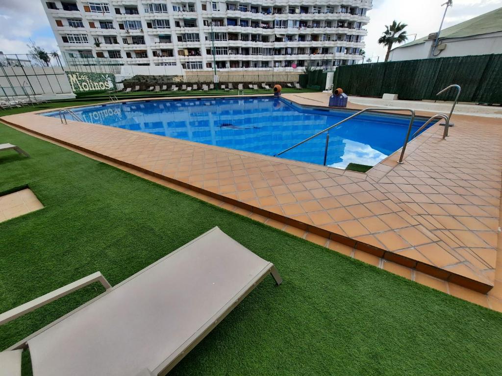 an overhead view of a large swimming pool with green grass at Playa del Inglés Céntrico Los Molinos 135 in Playa del Ingles