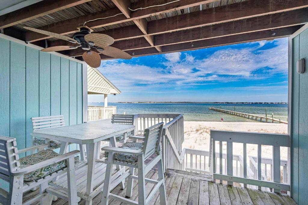 a porch with a table and chairs on the beach at Boardwalk D6 in Pensacola Beach