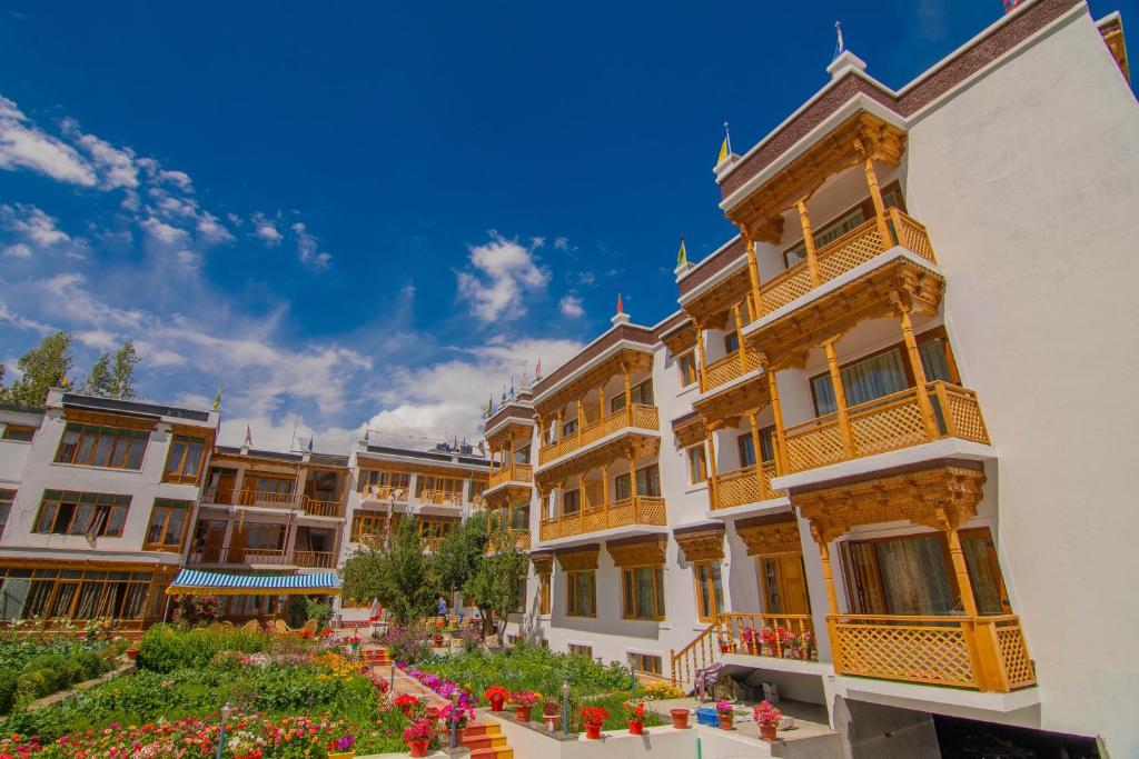 a group of buildings with flowers in a courtyard at Hotel Jigmet, Leh in Leh