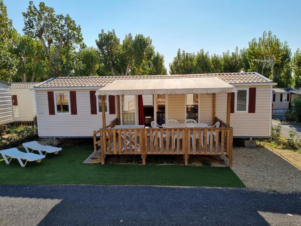 a mobile home with a porch and a deck at Mobilhome des sables in Valras-Plage