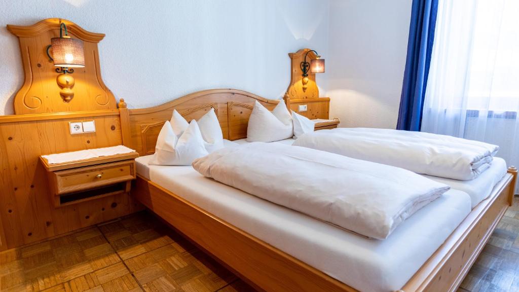 Postel nebo postele na pokoji v ubytování Aktivhotel & Gasthof Schmelz Ihr Urlaubs Hotel in Inzell mit Wellness Hallenbad, Alpensauna & Dampfbad