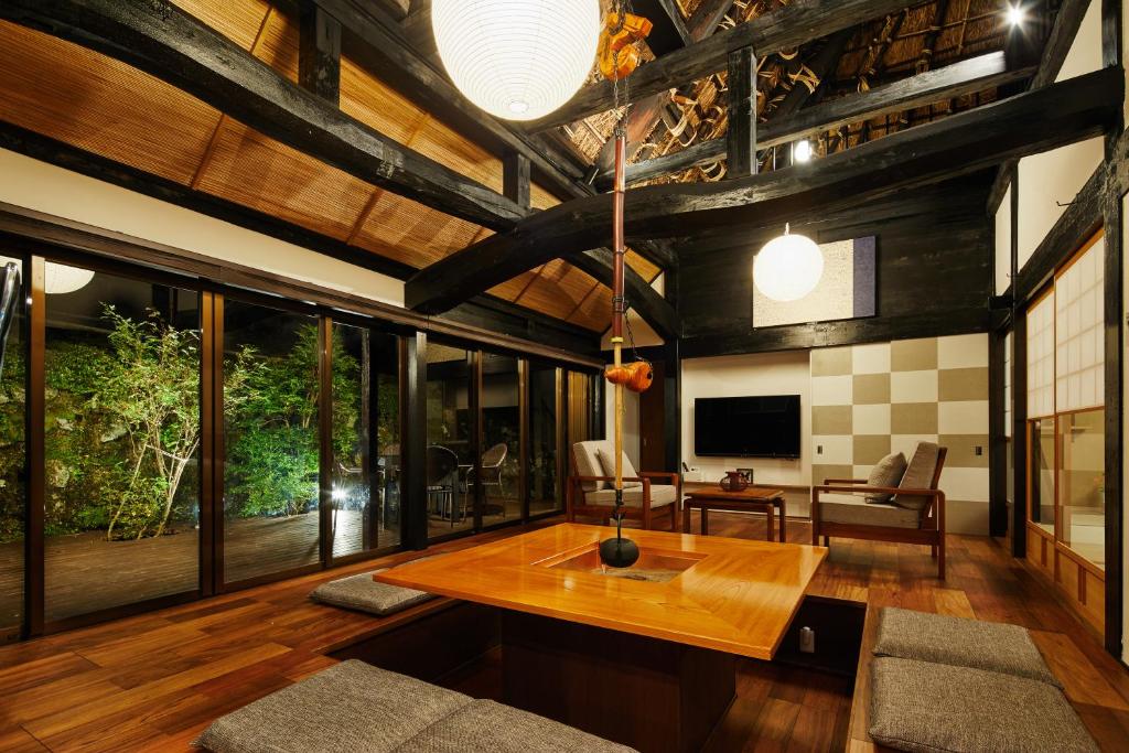 - un salon avec une table en bois et des chaises dans l'établissement 芹生庵, à Kyoto