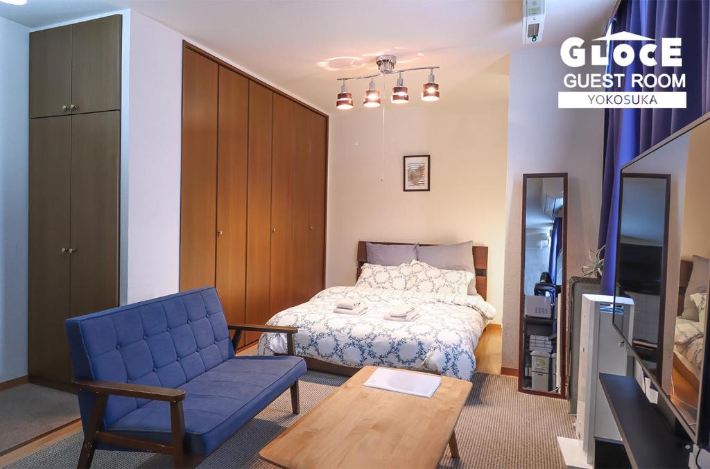 um quarto com uma cama e uma cadeira azul em GLOCE 横須賀 ゲストルーム 横須賀海軍基地 l Yokosuka Guest Room at NAVY BASE em Yokosuka
