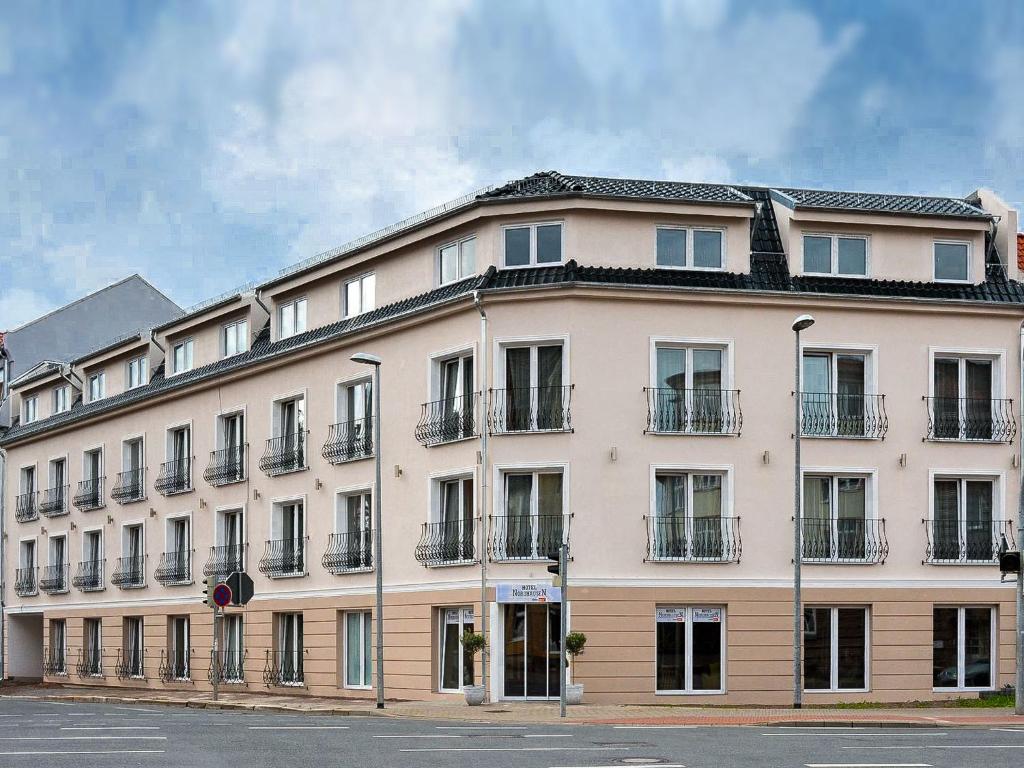 ein großes weißes Gebäude mit vielen Fenstern in der Unterkunft Hotel Nordhausen in Nordhausen
