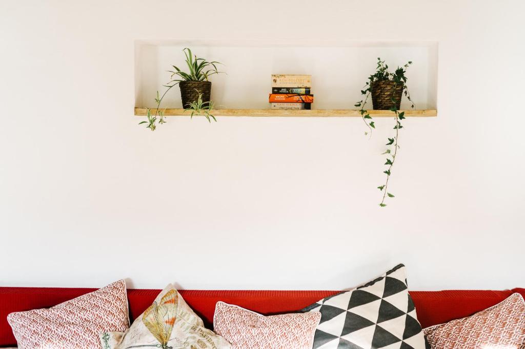 un estante sobre un sofá rojo con almohadas en Quinta do Arade - Casa Girassol, en Silves