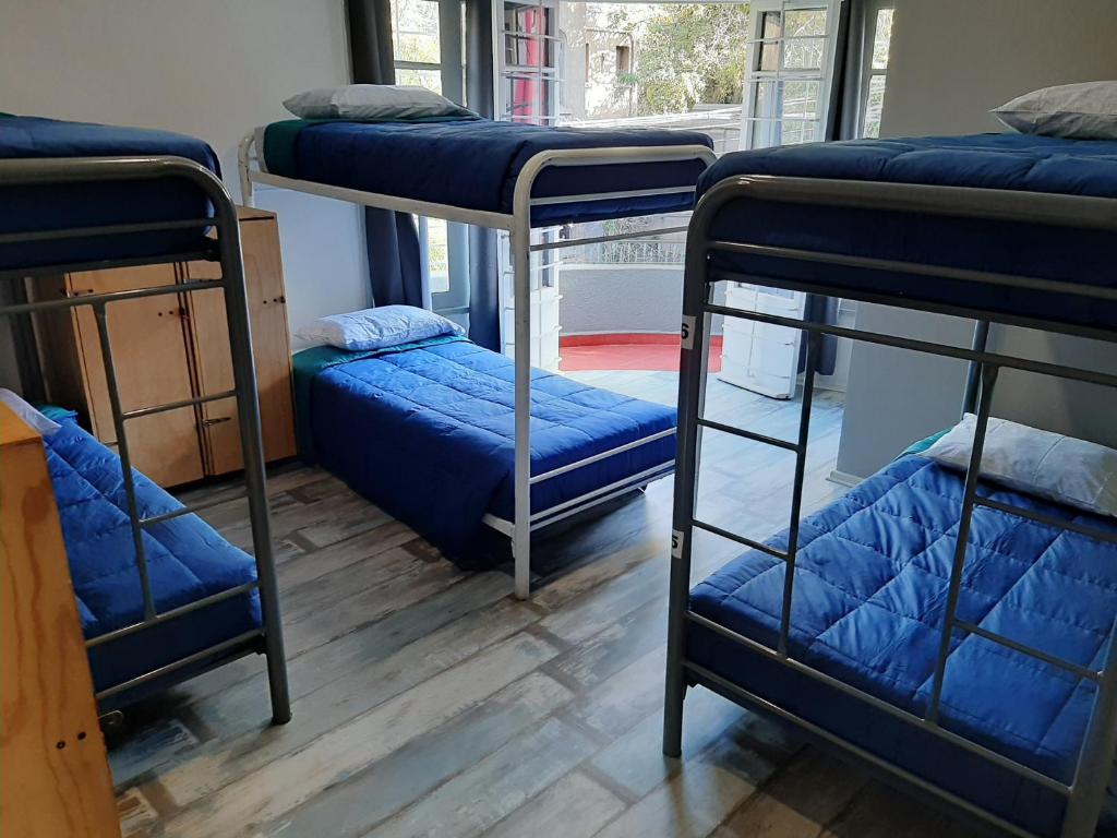 a room with three bunk beds and a window at Aji Hostel in Santiago