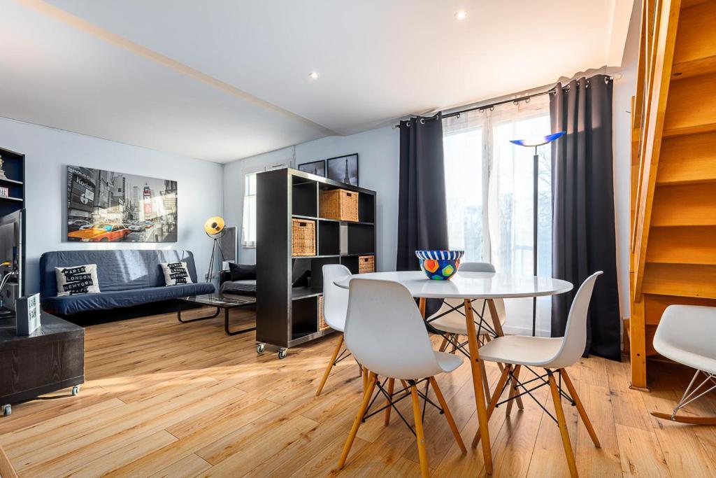 een eetkamer en een woonkamer met een tafel en stoelen bij Paris Roissy CDG : Top Duplex - 3 bedrooms in Roissy-en-France