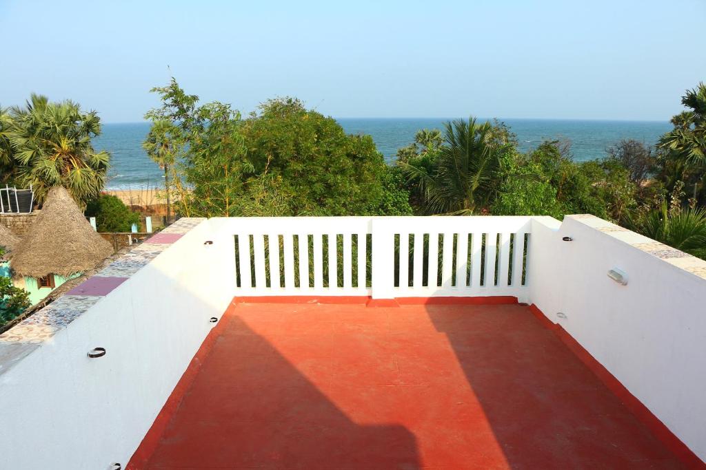a balcony with a white fence and a red floor at Bluetique Beach House in Auroville