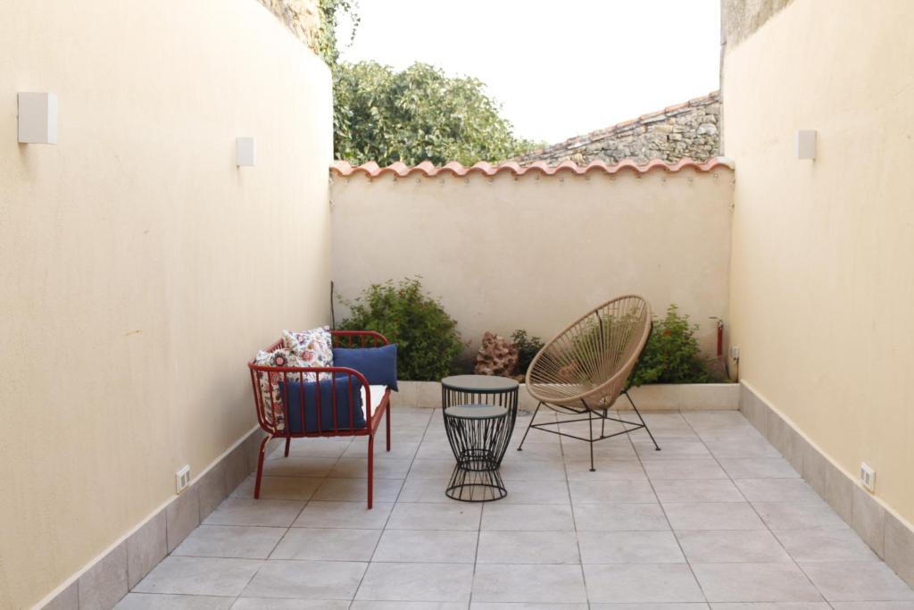 un patio con sillas, una mesa y una valla en La Casa del Patio Chico, en Aldeadávila de la Ribera